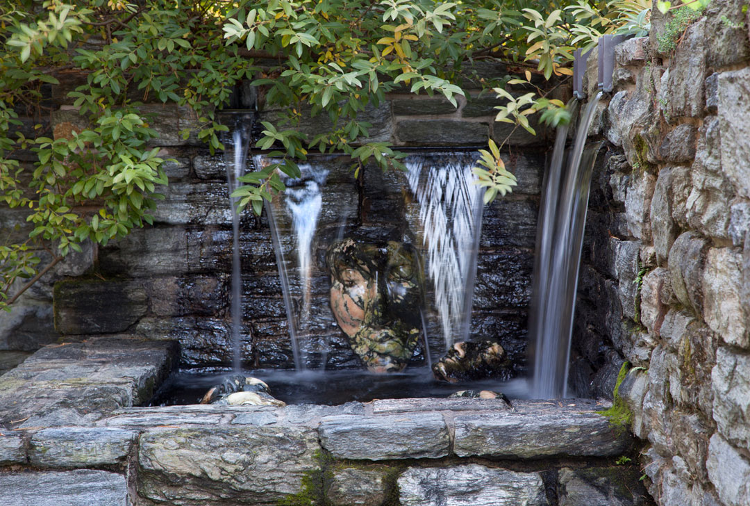 Cascatas de Água AO Longo de hum Rosto de pedra esculpidos no Garden Ruin.  <h6> Photo by Lisa Roper </ h6>
